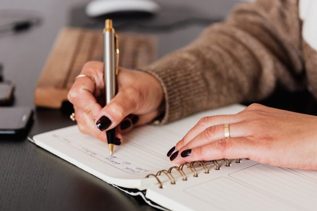 preparatório IELTS da englishprep. Student writing with pen on a notebook taking notes for an englishprep lesson