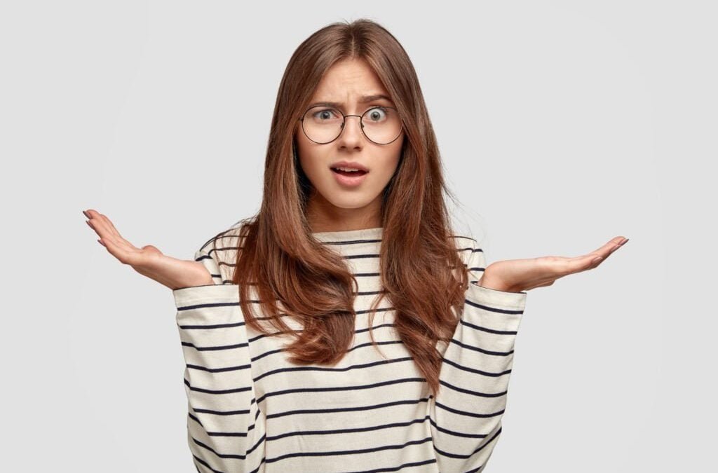 questioned-indignant-pleasant-looking-brunette-woman-with-hands-hesitant-gesture-wears-striped-casual-sweater-