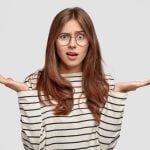 questioned-indignant-pleasant-looking-brunette-woman-with-hands-hesitant-gesture-wears-striped-casual-sweater-