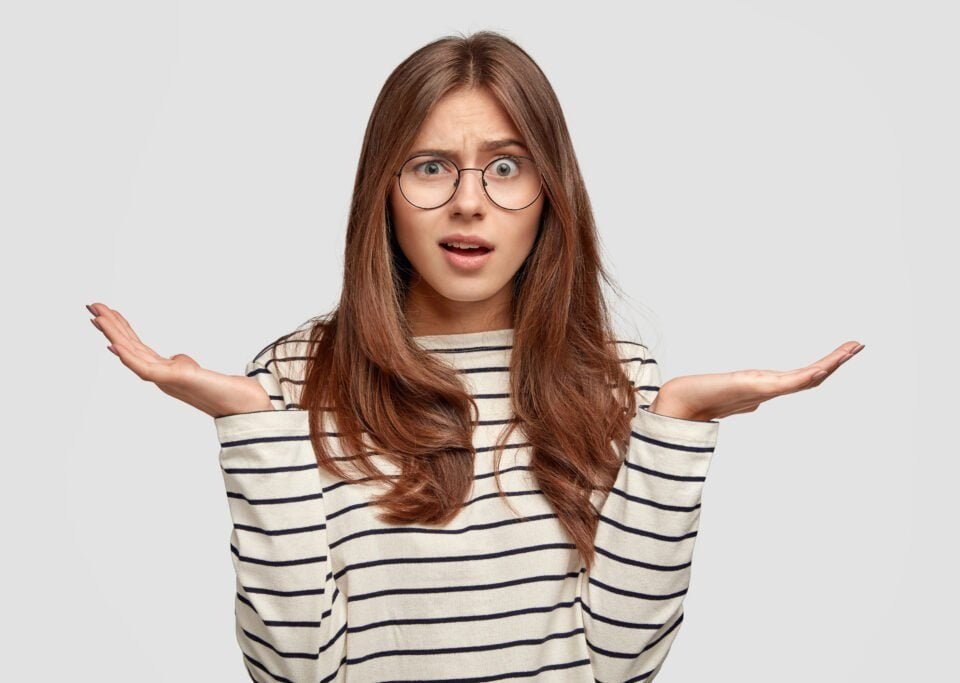 questioned-indignant-pleasant-looking-brunette-woman-with-hands-hesitant-gesture-wears-striped-casual-sweater-