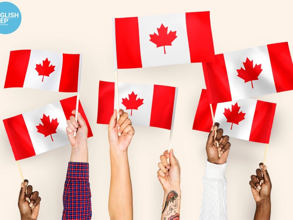 hands with canadian flags being held up by students who moved to canada after passing the IELTS test