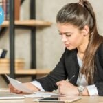 ielts examiners looking over a students writing test with formal clothing in office